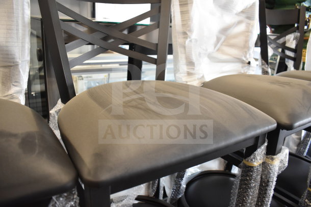12 brand new Lancaster Table & Seating black cross-back bar height chairs with seat cushions, visible minor scratches.