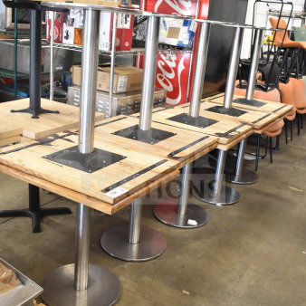 Set of 10 wooden dining tables with metal bases, auctioned as a lot. Tables show sturdy metal supports and natural wooden tops.