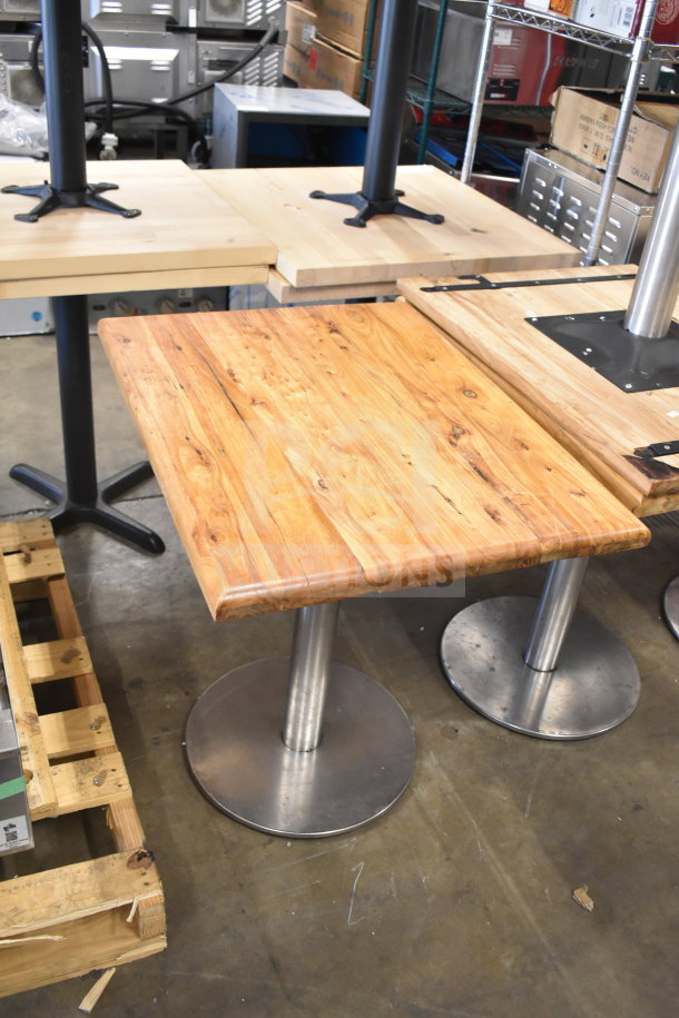 Wooden dining-height table with metal base, 10 available, excellent condition. Natural wood grain top, sturdy round metal support.