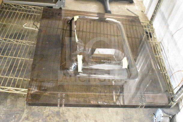 Brand new vacuum sealer lid with scratches and dents, transparent material, visible protective tape.