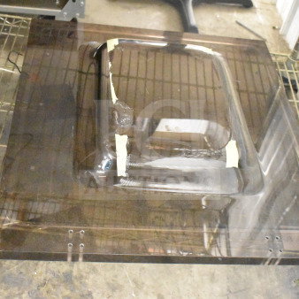 Brand new vacuum sealer lid with scratches and dents, transparent material, visible protective tape.