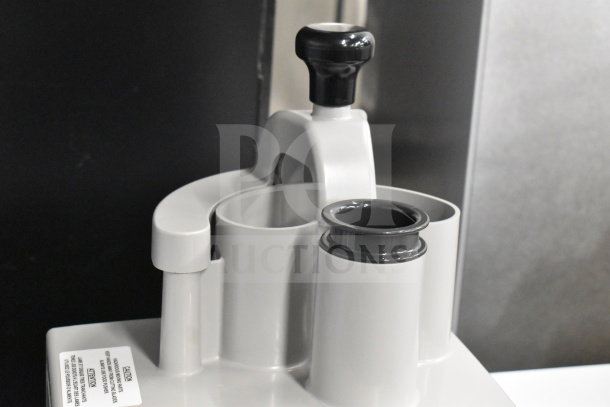 Gray poly continuous feed head for food processor, brand new with minor dents, visible caution label.