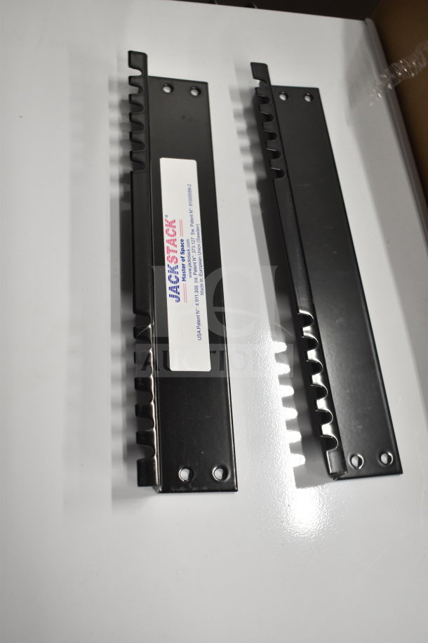 Two JackStack JS012HW wall-mounted plate racks, black, each with a label displaying product info, for holding 12 plates.