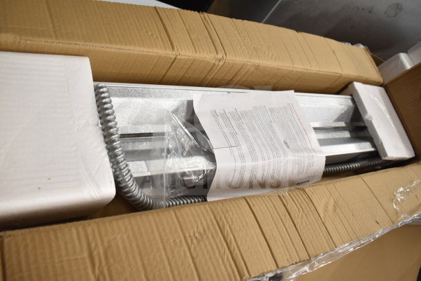 Brand new ServIt 36" strip warmer in original packaging, single toggle control, 120V, 850W, minor scratches and dents visible.