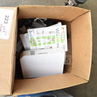 Cardboard box containing a Nintendo Wii console, Wii controllers, WiiFit Plus and WiiSports games. Box labeled "223."