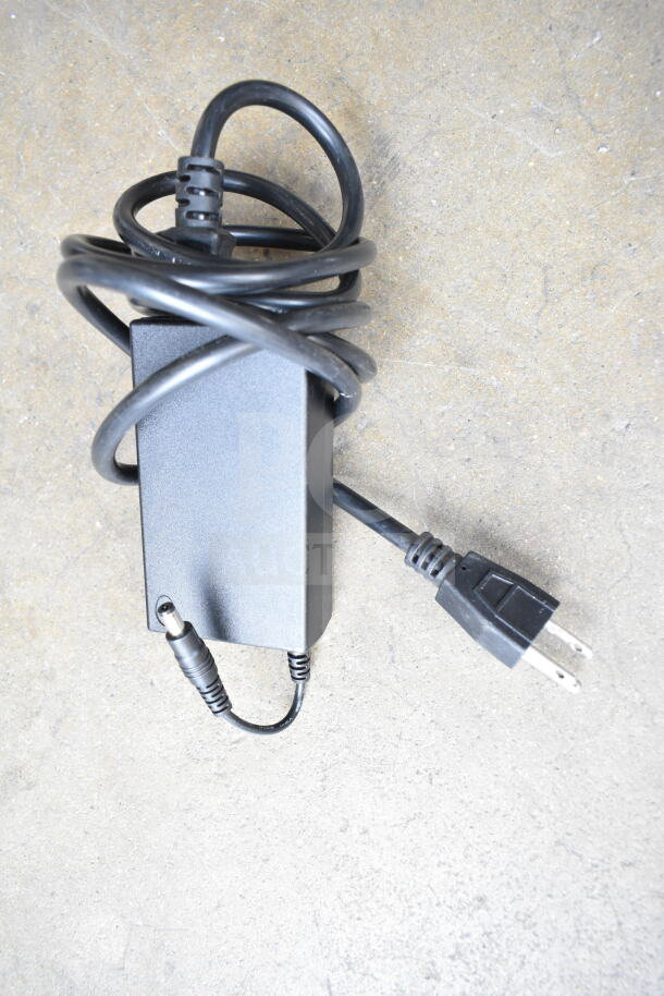 Nintendo Wii power adapter in good condition, features a coiled black cable and a standard two-prong plug.