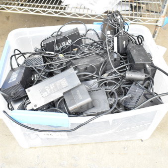 Poly bin with assorted cords and battery charger, various brands visible. Ideal for electronics salvage. Used condition.