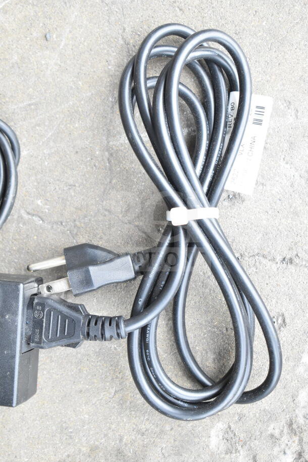 Lot of various cords and a battery charger, tied with a white zip tie. Includes a "Made in China" label.