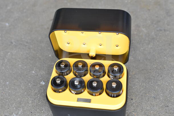 Lot of various cords and battery charger in a clear poly bin. Charger features eight slots, black and yellow design.