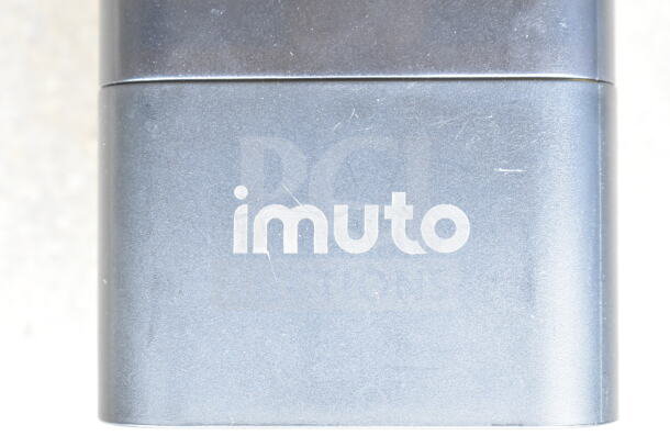 Lot of various cords and an Imuto battery charger in a clear poly bin. Visible Imuto branding on charger.