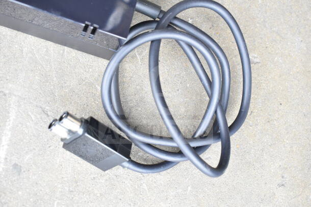 Lot of various cords and a battery charger in a clear poly bin. Cords shown coiled; charger details not visible. Good condition.