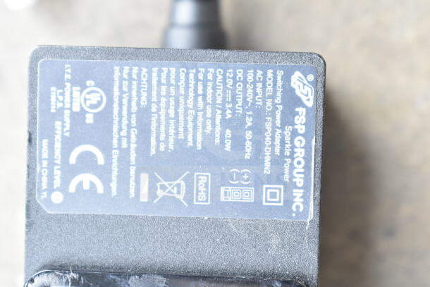 Clear poly bin containing various cords and an FSP Group battery charger. Charger label: Model No. FSP040-DHMN2, inputs 100-240V, output 12V, 3.3A.