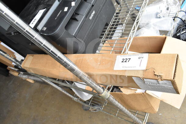 Cardboard box labeled "DP/N 053D7M Brackets" on a metal cart. Box shows some wear. Auction tag number 227 visible.