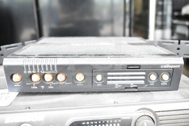 Cradlepoint AER2200 router with multiple antenna ports, shown atop a Samson Servo 120a amplifier. Visible condition is good.