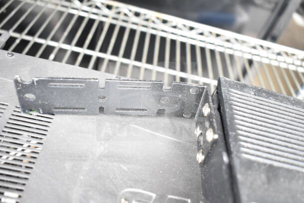 Cradlepoint AER2200, Samson Servo 120a, SynOptics LattisHub 2814 on metal shelf; visible dust and wear.