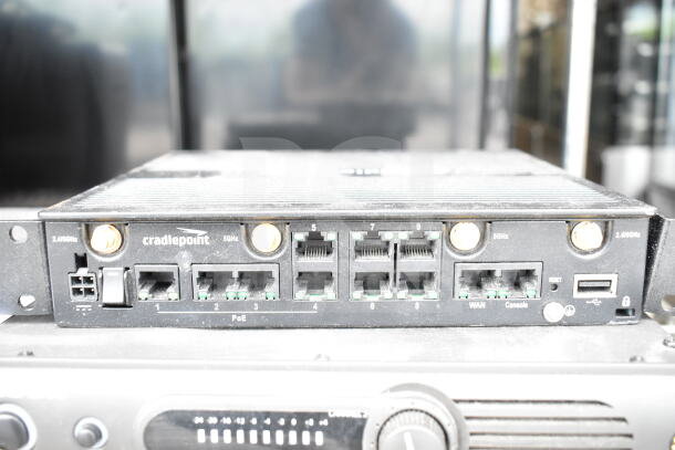 Cradlepoint AER2200 router with multiple Ethernet ports, visible brand logo, and frequency markings.
