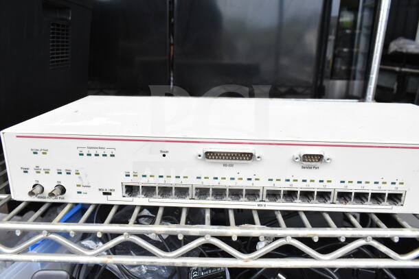 Cradlepoint AER2200 router, partially visible, on metal shelf. Includes ports and indicator lights. Good condition.