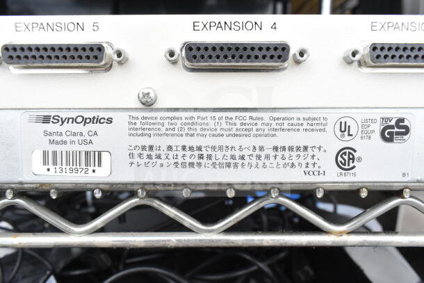 SynOptics LattisHub 2814 with expansion ports, compliance labels, and serial number. Made in USA.