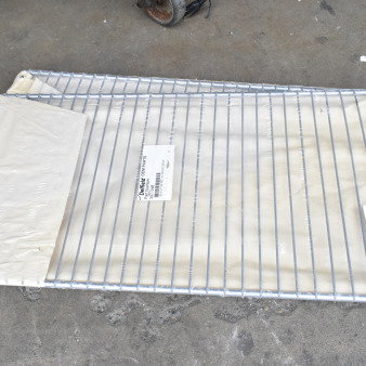 Two brand new Delfield 3977998 wire shelves, 19.38x25.25", in packaging. Some scratch and dent marks visible.