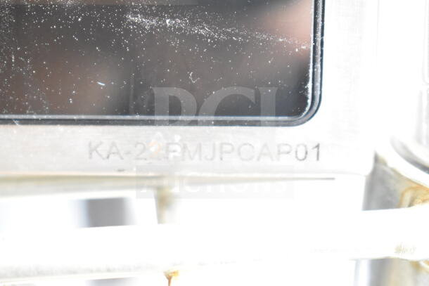 Close-up of a monitor with the marking "KA-22FMJPCAP01" on a metal frame, part of a lot with receipt printers.