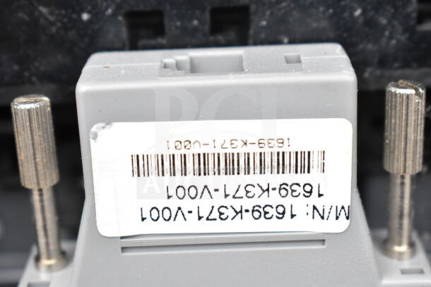 Close-up of a gray electronic component with a barcode label displaying model number 1639-K37-V001.