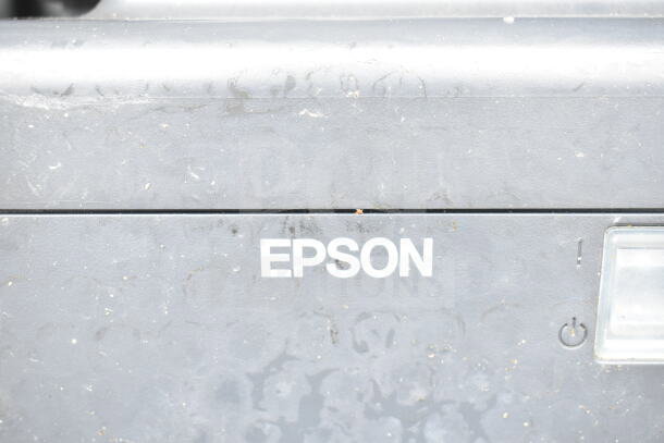 Epson receipt printer, gray exterior with visible wear, featuring power button. Part of 5-item auction lot including POS monitors and Dell printer.