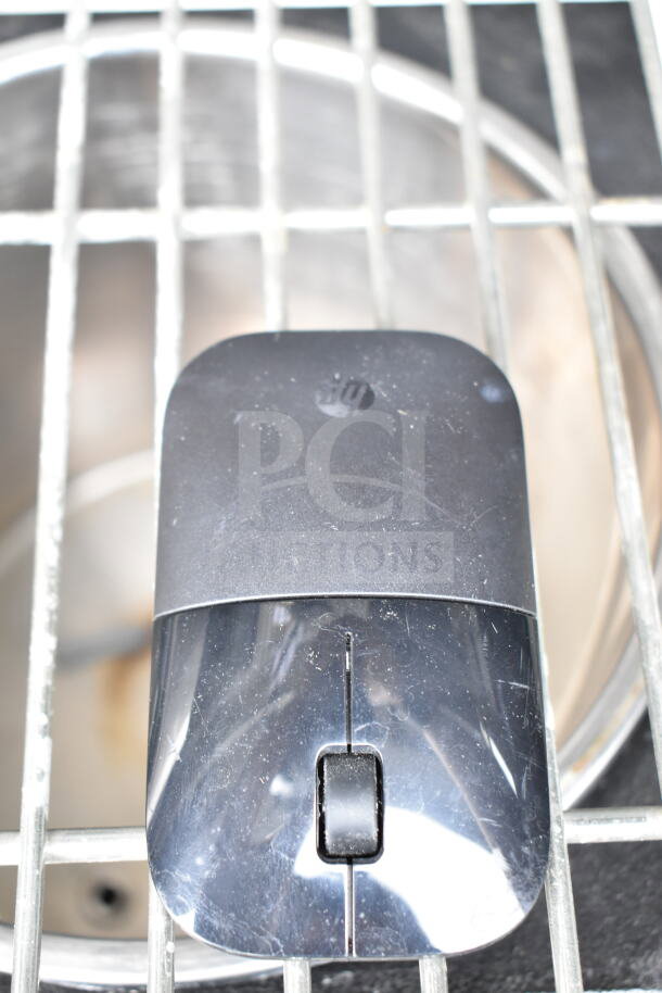 HP wireless mouse with visible wear. Black top with glossy finish. Logo on the surface.