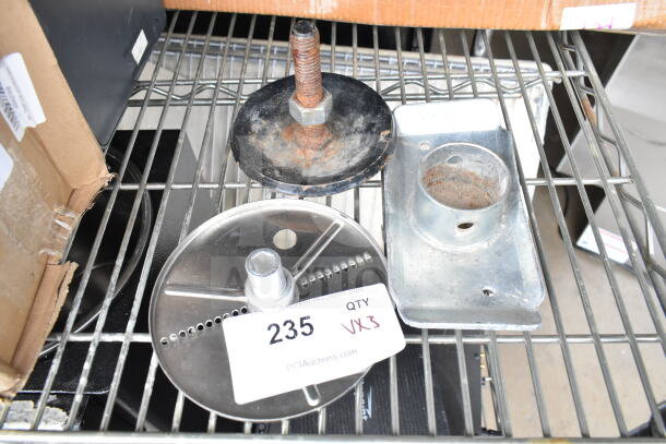 Food processor blade and two metal pieces on a shelf, tagged "235 QTY VX3" from PCI Auctions, some wear visible.