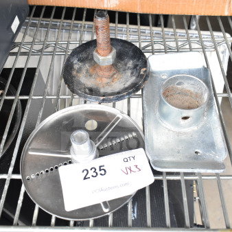 Food processor blade and two metal pieces on a shelf, tagged "235 QTY VX3" from PCI Auctions, some wear visible.