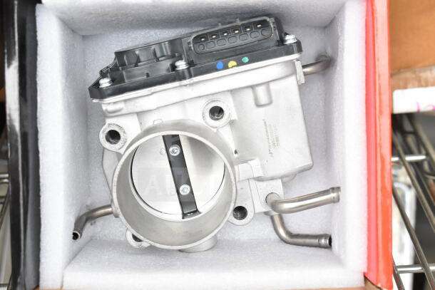 THBB1112-C throttle body in new condition, showcasing metallic components and electrical connectors in protective packaging.