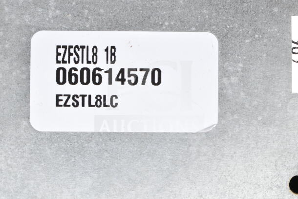 Elkay EZFSTL8 wall mount water fountain label, showing model number EZSTL8LC and serial number 060614570 on metallic surface.