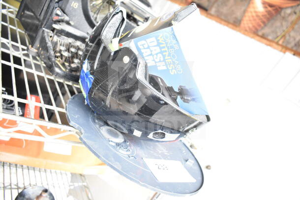 3 various items including a dash cam box, OnlyNY helmet, and Roomba on a shelf. Mixed condition.