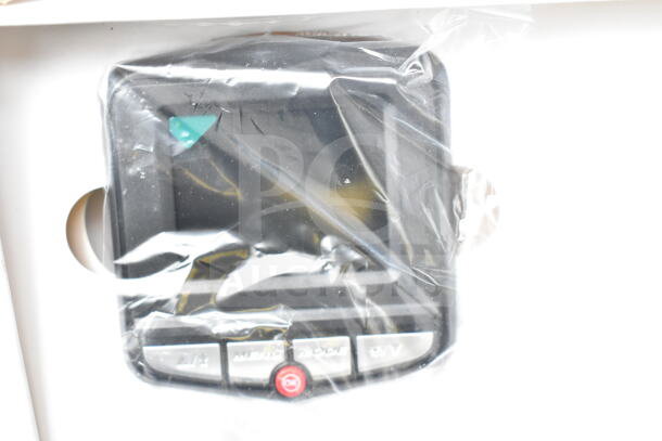 Plastic-wrapped dash cam with buttons and screen, part of auction set. Condition unknown.