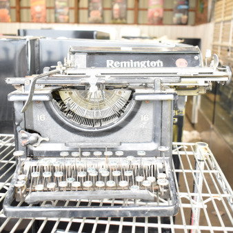 Remington countertop typewriter, vintage model 16, featuring classic keys and worn metal finish. Condition appears used.
