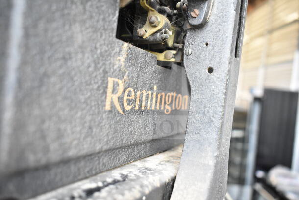 Remington countertop typewriter with visible mechanical components, marked with "Remington" logo, in vintage condition.