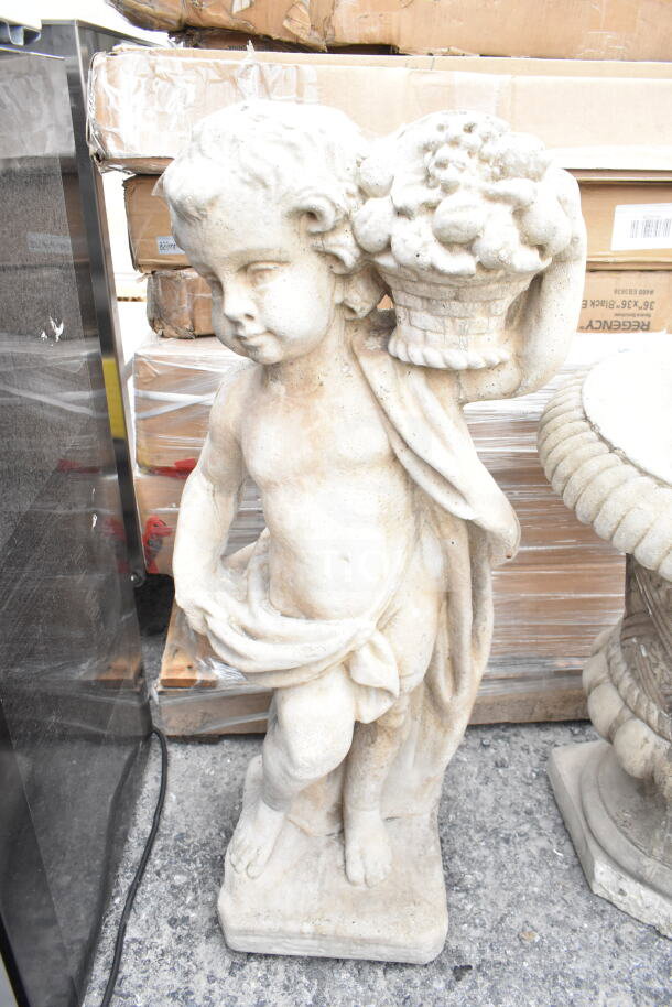 Stone statue depicting a cherub with a fruit basket. Weathered condition, intricate detail, standing on a square base.
