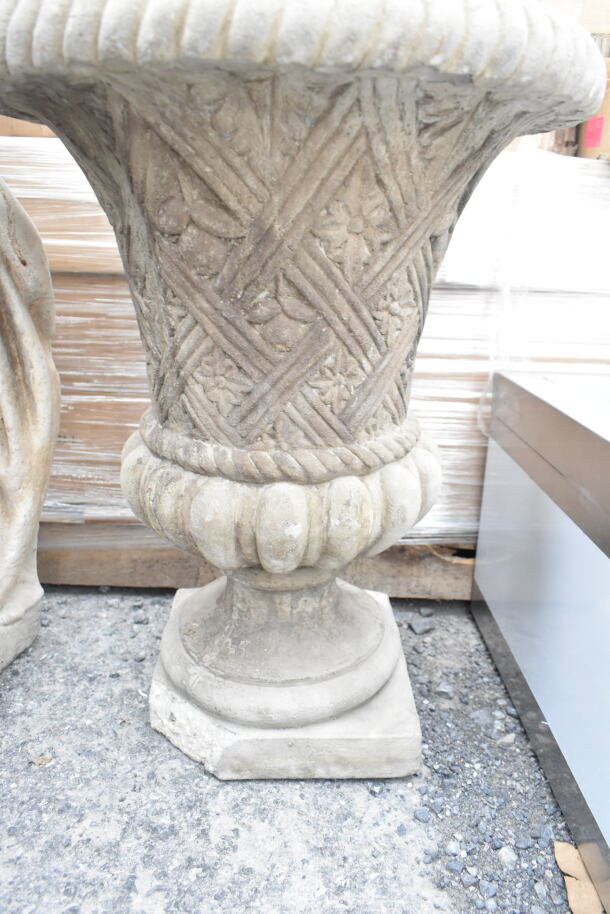 Stone vase with intricate carvings, weathered texture, standing on a square base. Part of a statue and vase auction set.