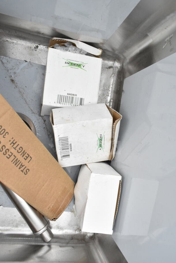 Alt text: Regency 600S3181818C corner sink with drainboards, brand new with visible scratches and packaging materials.
