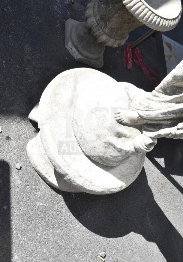 Stone statue depicting draped figure, visible from the base with detailed folds and smooth finish, minor wear evident.