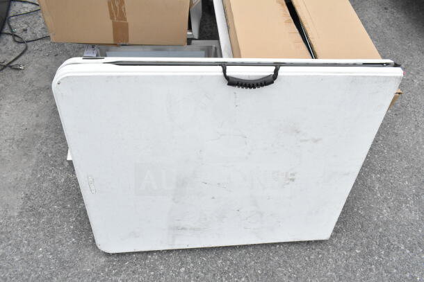 Lifetime Bi-Fold Folding Table, white, with handle; visible wear; compact and portable for easy storage.