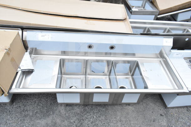 Three-compartment KoolMore SC101410-12B3 54-inch stainless steel sink, brand new with visible scratches and dents.