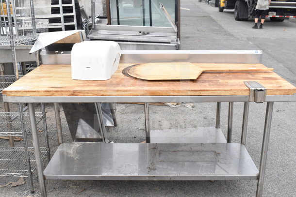 Butcher block table with under shelf, featuring a wood surface, stainless steel frame, used condition. Includes wooden board and cover.