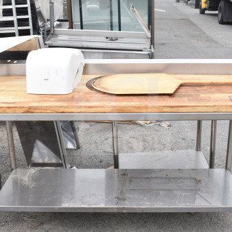 Butcher block table with under shelf, featuring a wood surface, stainless steel frame, used condition. Includes wooden board and cover.