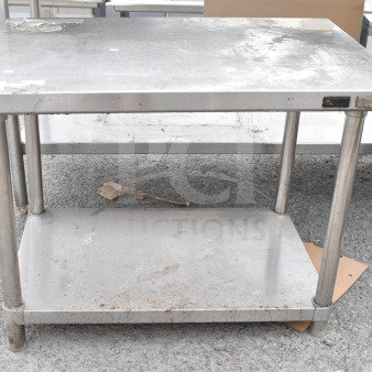 Stainless steel table with under shelf, showing signs of wear and discoloration. Ideal for industrial or kitchen use.