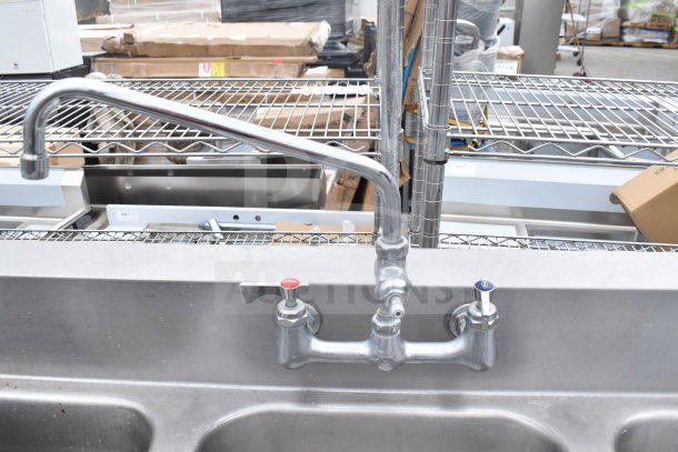 Commercial 3 bay sink with dual drain boards, faucet, and spray nozzle attachment. Stainless steel, excellent condition.