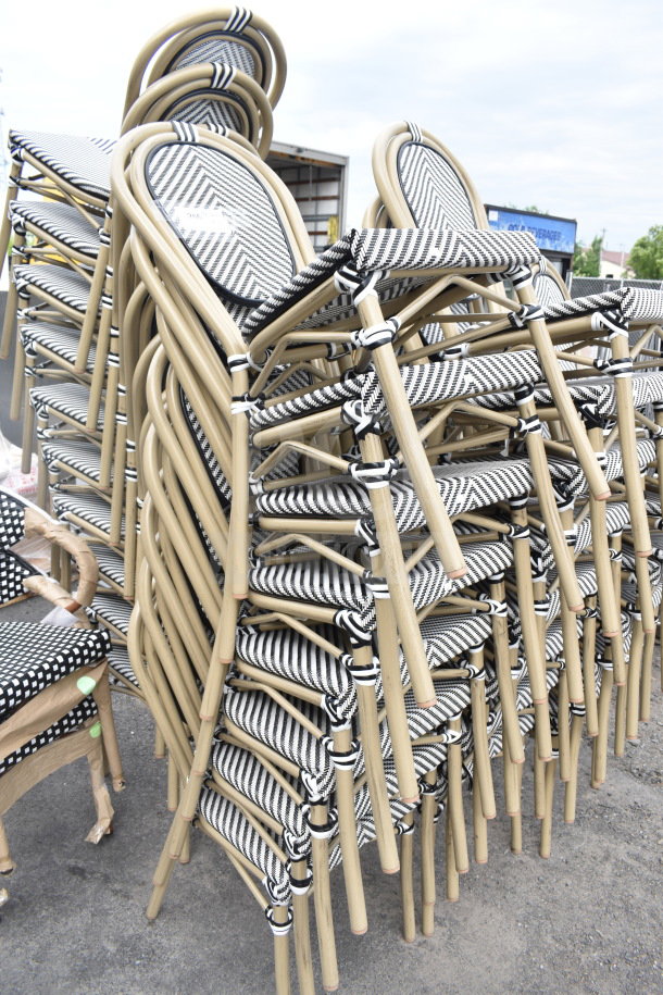 Stacked set of 32 brand new chairs with scratch and dent; beige frames, black-and-white striped seats.