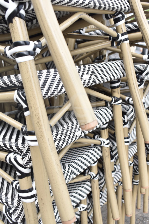 Stacked black and white woven chairs with tan frames, scratch and dent, brand new, auction for 32 pieces.