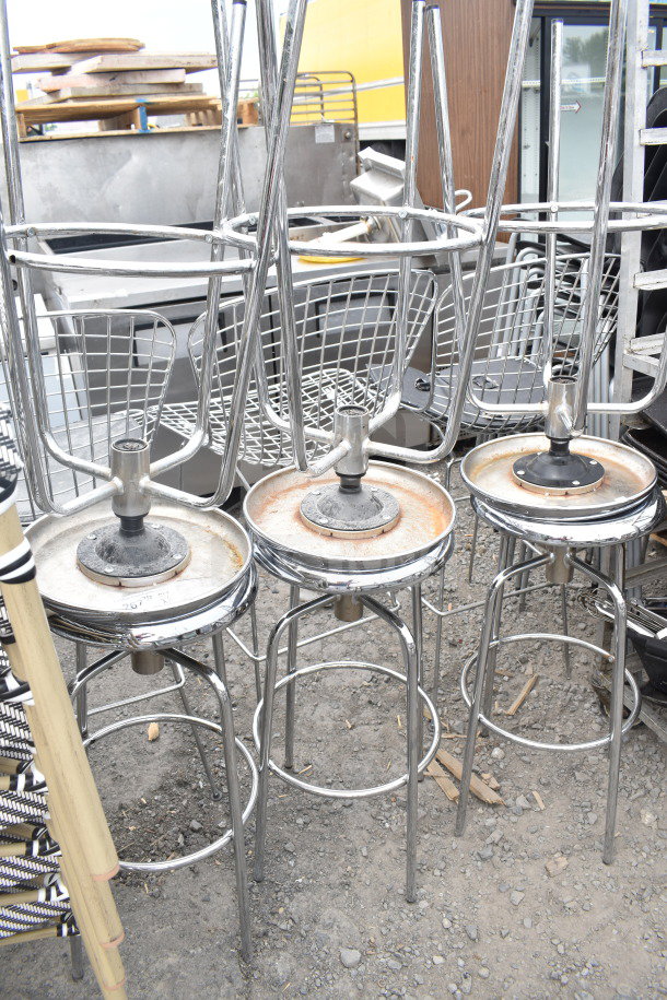 6 metal stools with chrome frames, circular bases, and wire backrests. Slight rust on seat bases. Auction lot of 6.