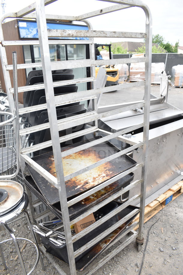 Commercial pan transport rack with multiple shelves, visible wear, and sturdy commercial casters; ideal for kitchen use.