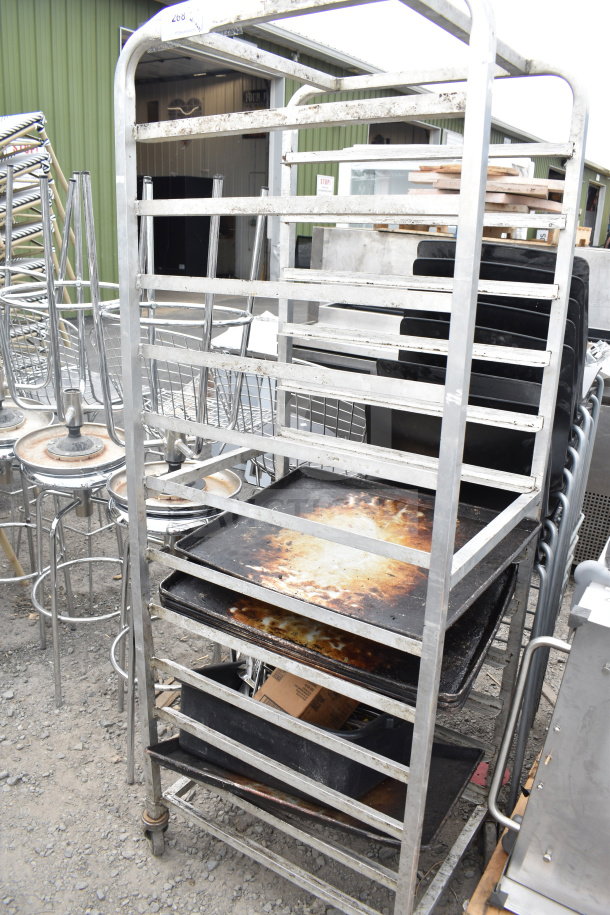 Commercial pan transport rack with multiple shelves and sturdy casters, showing signs of wear, ideal for kitchen use.